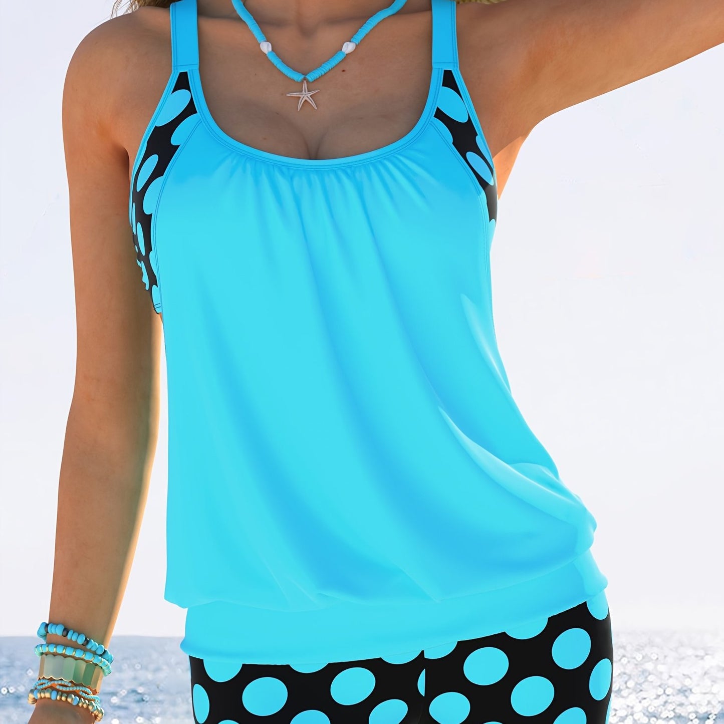 Yellow and black polka dot tankini set for women made of stretchy polyester/elastane blend. Includes round neck top with ruched design and high-waisted shorts. Machine washable. Ideal for