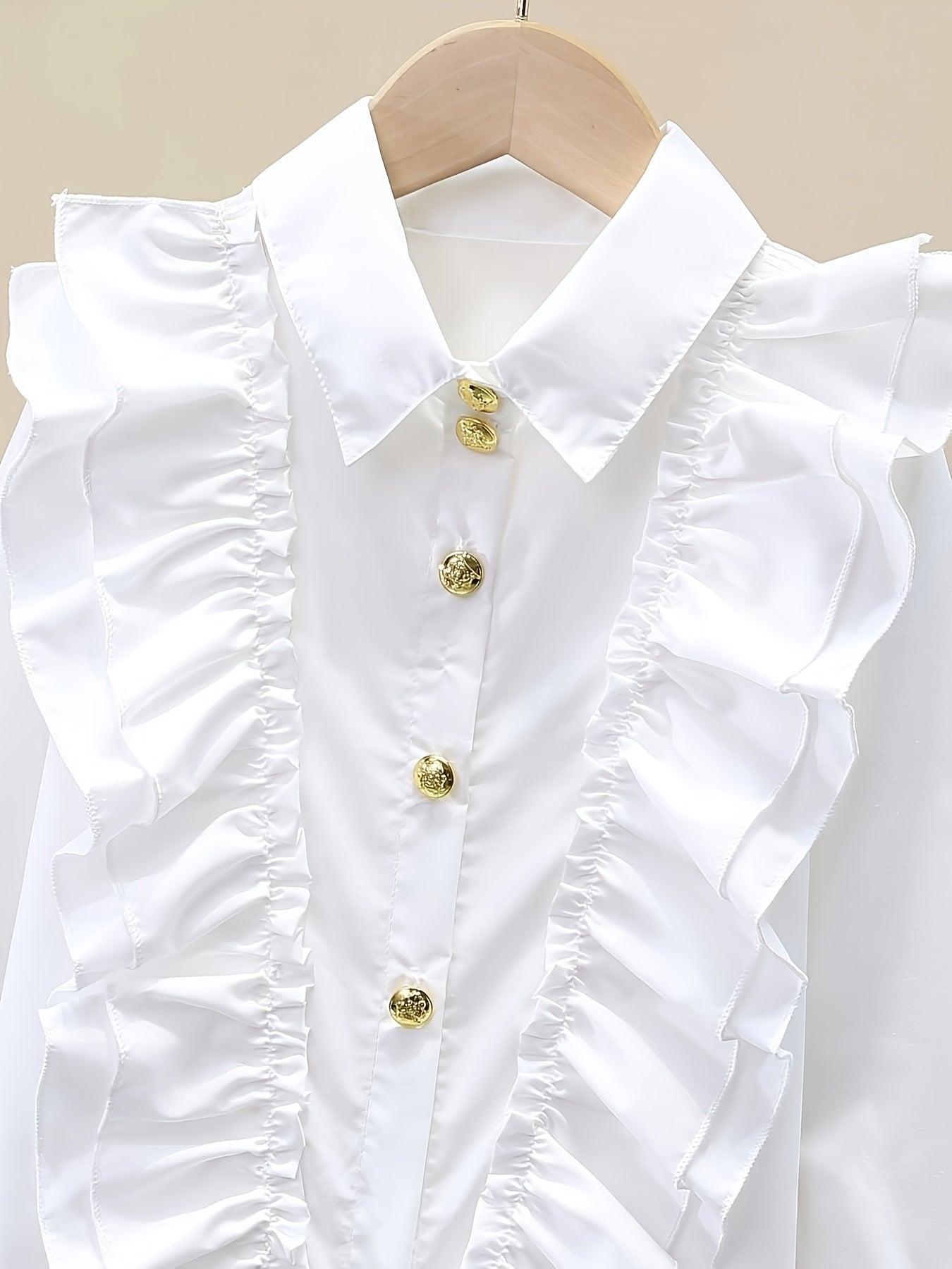 Stylish girls' long-sleeve dress shirt with ruffled cuffs and metal buttons - perfect for school uniforms or fashionable looks.