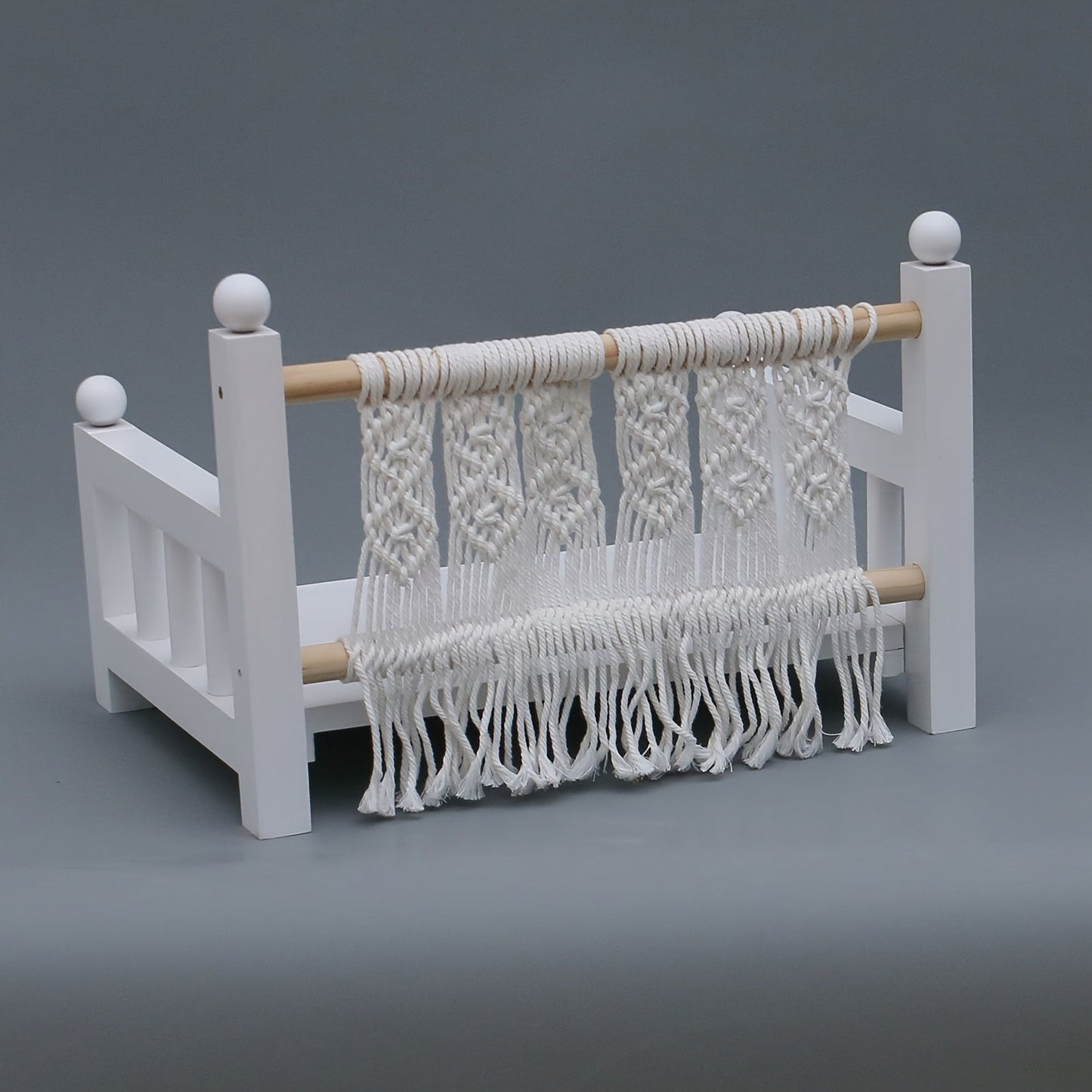 Photography props for baby photos include a white wooden crib bed.