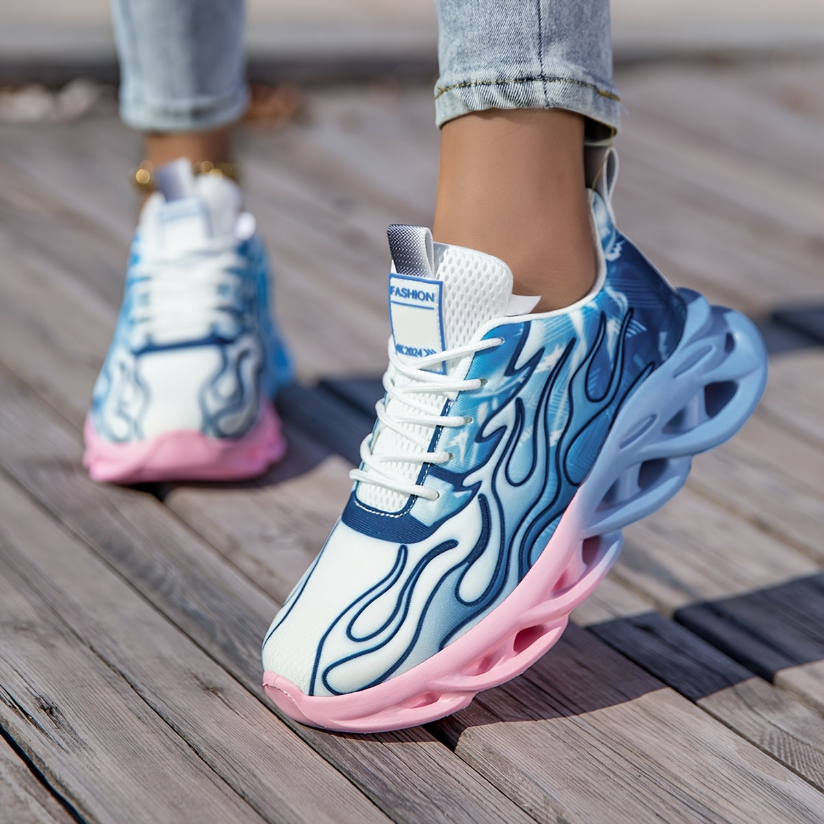 Versatile all-season lightweight running shoes in blue and pink ombre with breathable fabric and lace-up closure.