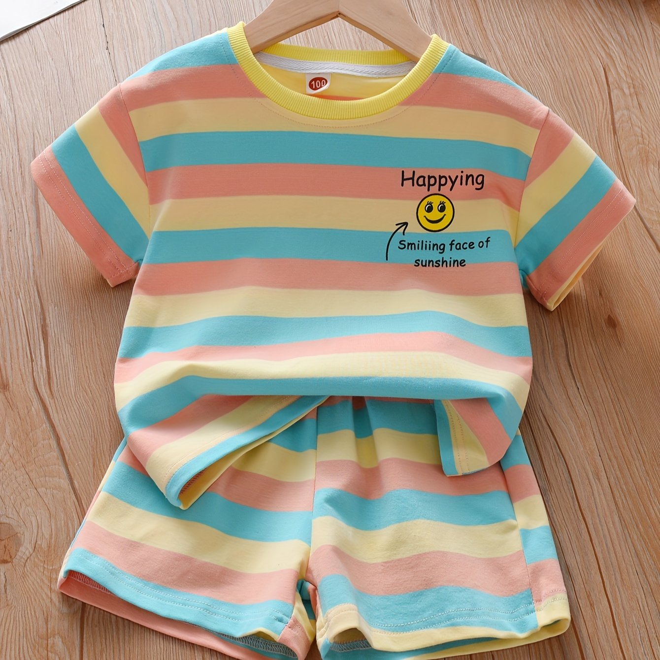 Summer fashion set for girls: Cute T-shirt with joyful face & letter print paired with striped shorts. Made of cotton blend, machine washable, ideal for outdoor activities.