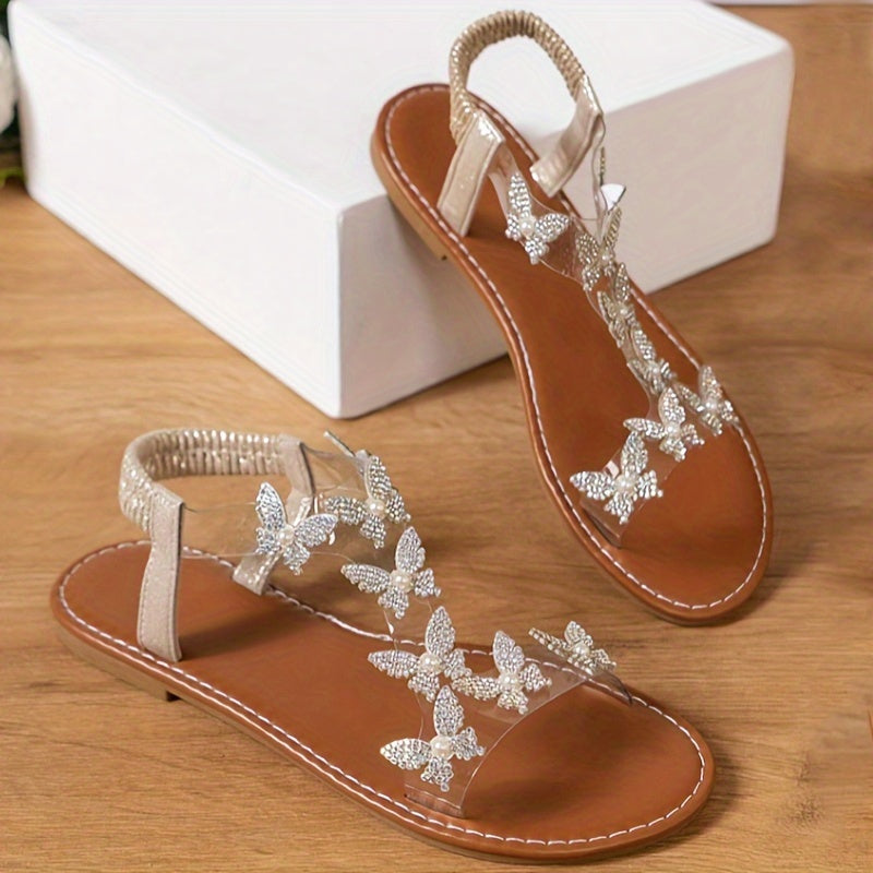 Stylish flat sandals adorned with an elegant rhinestone butterfly and transparent straps, perfect for outdoor wear and beach vacations.