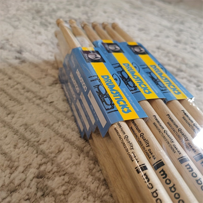 Set of 12 pairs of 5A/7A oak drumsticks for percussion instruments, jazz drumming, and electronic drums. Premium wood grain design for beginners and professional drummers. Labeled as