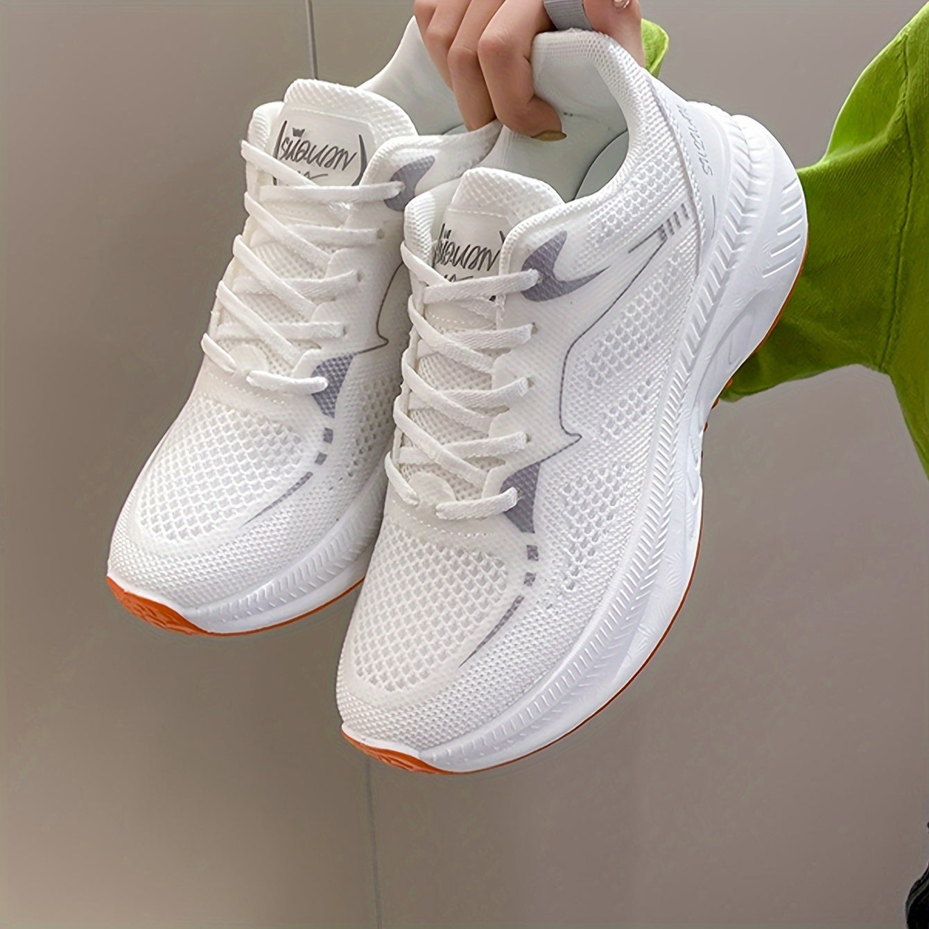 Women's low-top running shoes in white with orange sole, breathable fabric upper, rubber sole, stabilizing support, all-season casual sneakers.