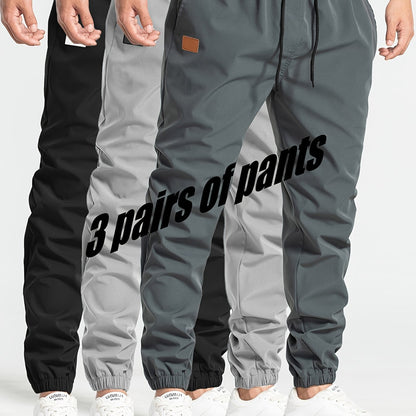 Three-pack of men's loose casual pants in 100% polyester solid color, featuring multi-pocket waist drawstring and non-stretch woven fabric, part of the Spring Collection, 180g/m².