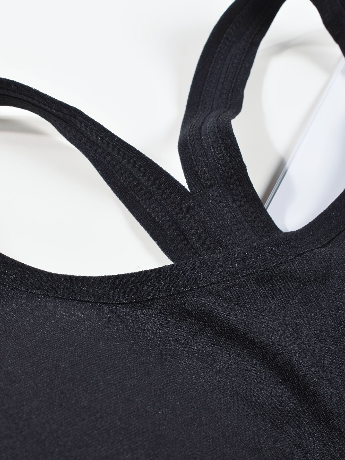 High-support sports bra for women with adjustable back buckle, removable pads, and cross-back design. Great for yoga, fitness, and running. Made with breathable nylon fabric.