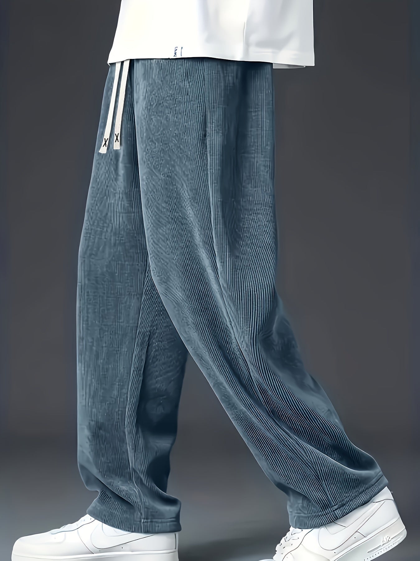 Loose straight-leg corduroy sweatpants in solid color, made of polyester blend with pockets and non-stretch fabric.