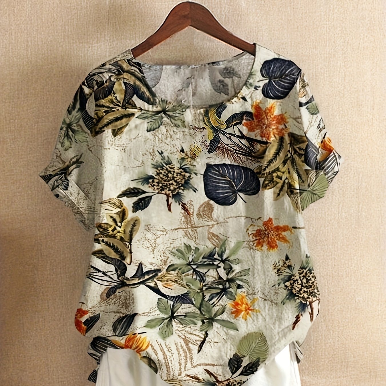 Plus size tropical print blouse for women, casual and loose fit, short sleeve, round neck, polyester blend, machine washable, vibrant floral design with asymmetrical hem.