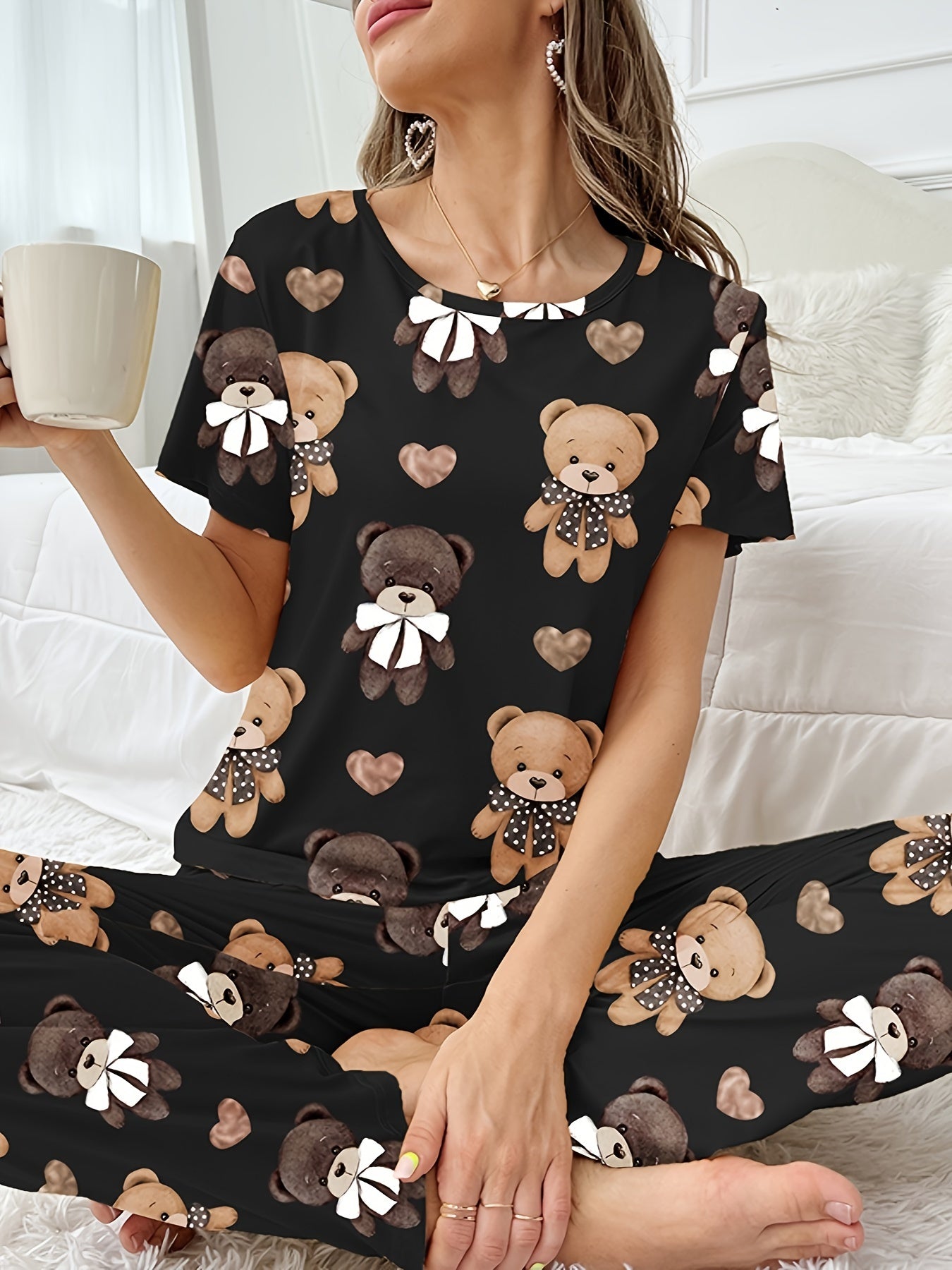 Women's sleepwear set with cartoon bear and heart print, featuring a cozy short sleeve top and elastic pants.