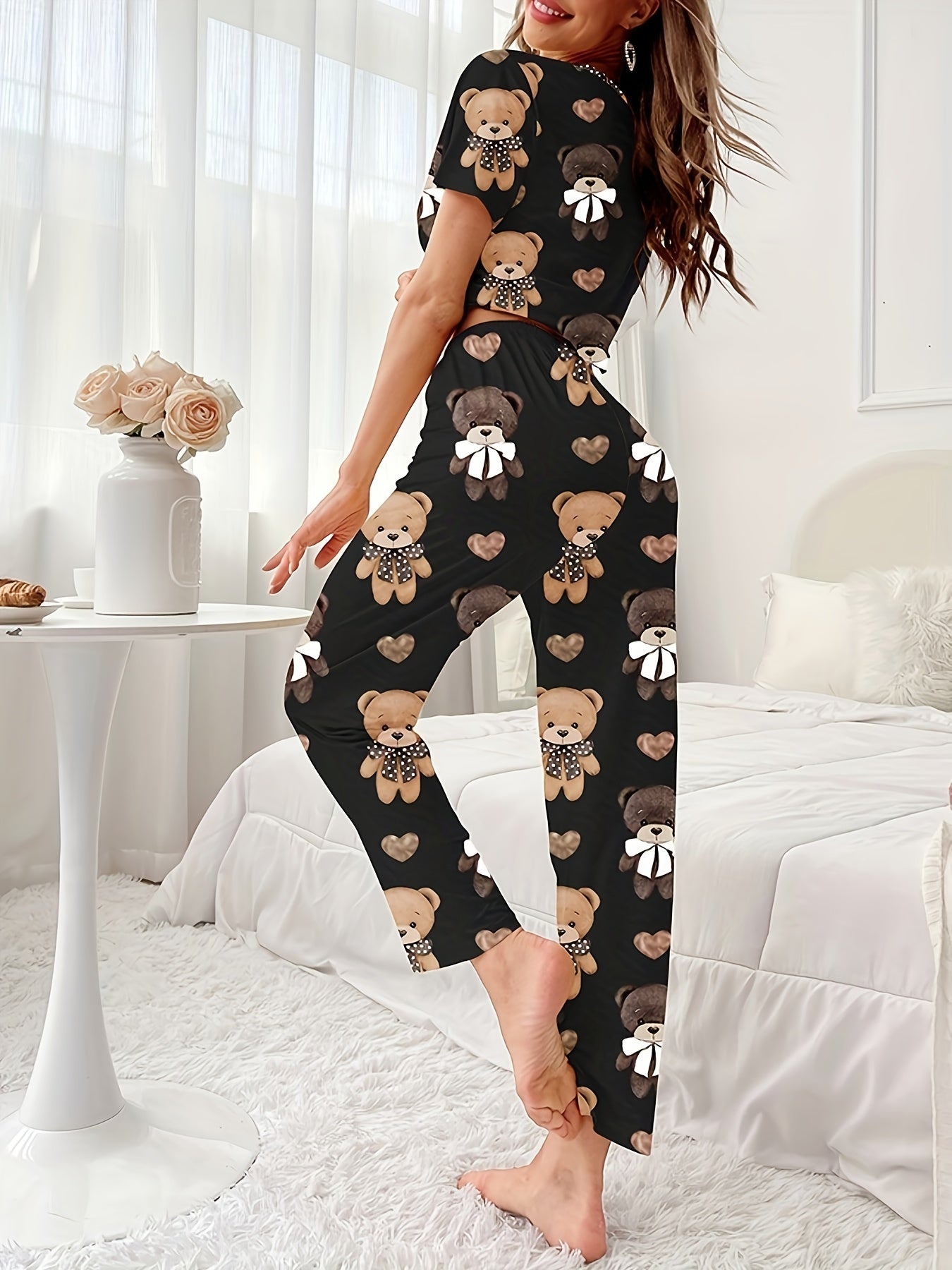 Women's sleepwear set with cartoon bear and heart print, featuring a cozy short sleeve top and elastic pants.