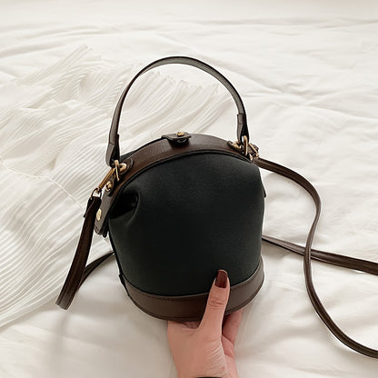 Fashionable women's bucket bag in two-tone brown and beige with gold hardware, ideal for travel and everyday use. Modern tote bag option.