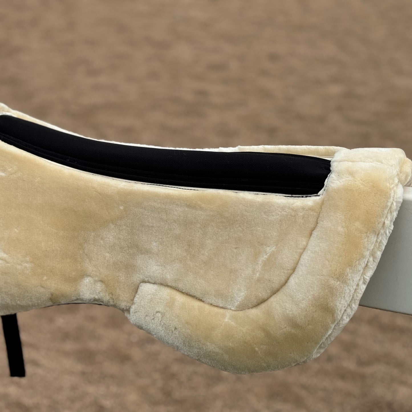 English saddle horse half pad with 100% woven fabric outer and shape-retaining foam insert, featuring a thick, soft, non-shedding synthetic sheepskin for easy cleaning.