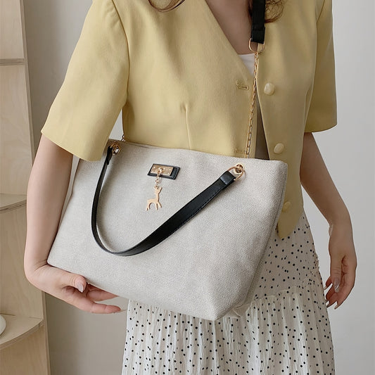 Polyester tote bag for women with deer charm, adjustable strap, zipper closure, painted edges, and messenger bag style.