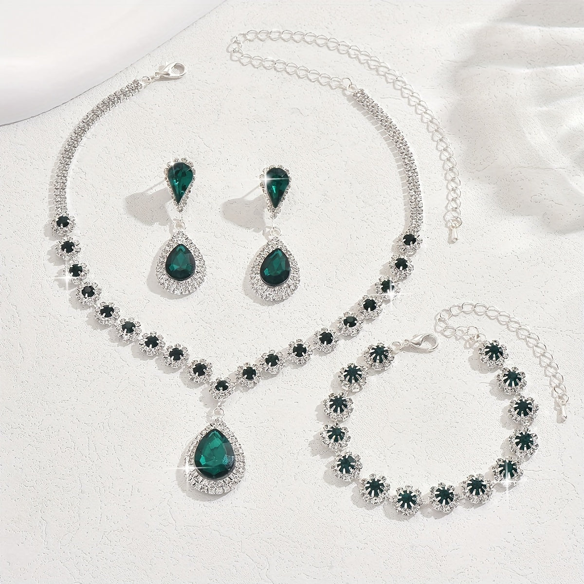 A set of three jewelry pieces for brides and ladies, including one necklace, one pair of earrings, and one bracelet, all featuring flower drop designs. Perfect accessories to complement any dress.