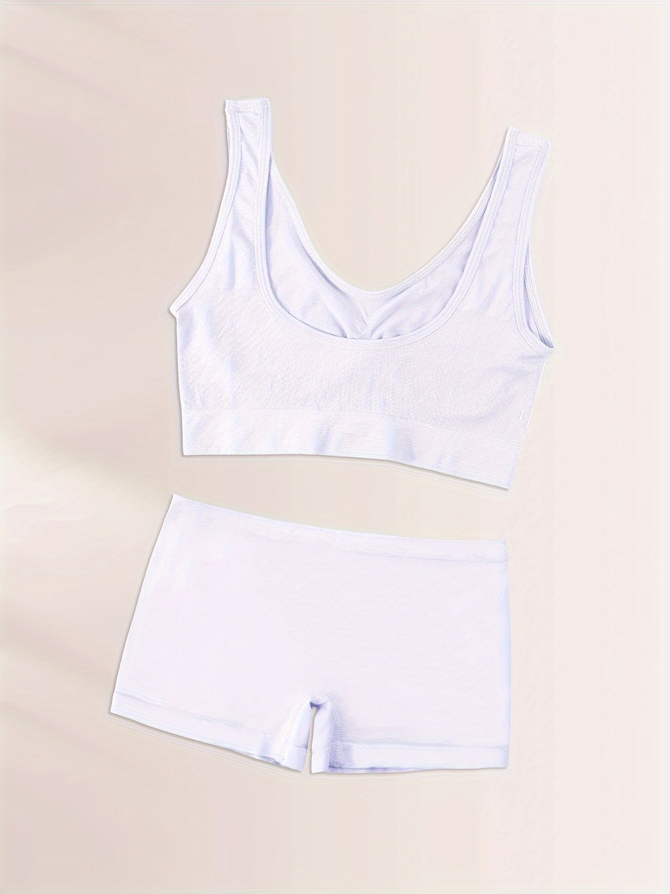 Seamless sports bra and high-waisted shorts set in breathable nylon with spandex blend, wire-free and padded, solid color casual adult pajama set.