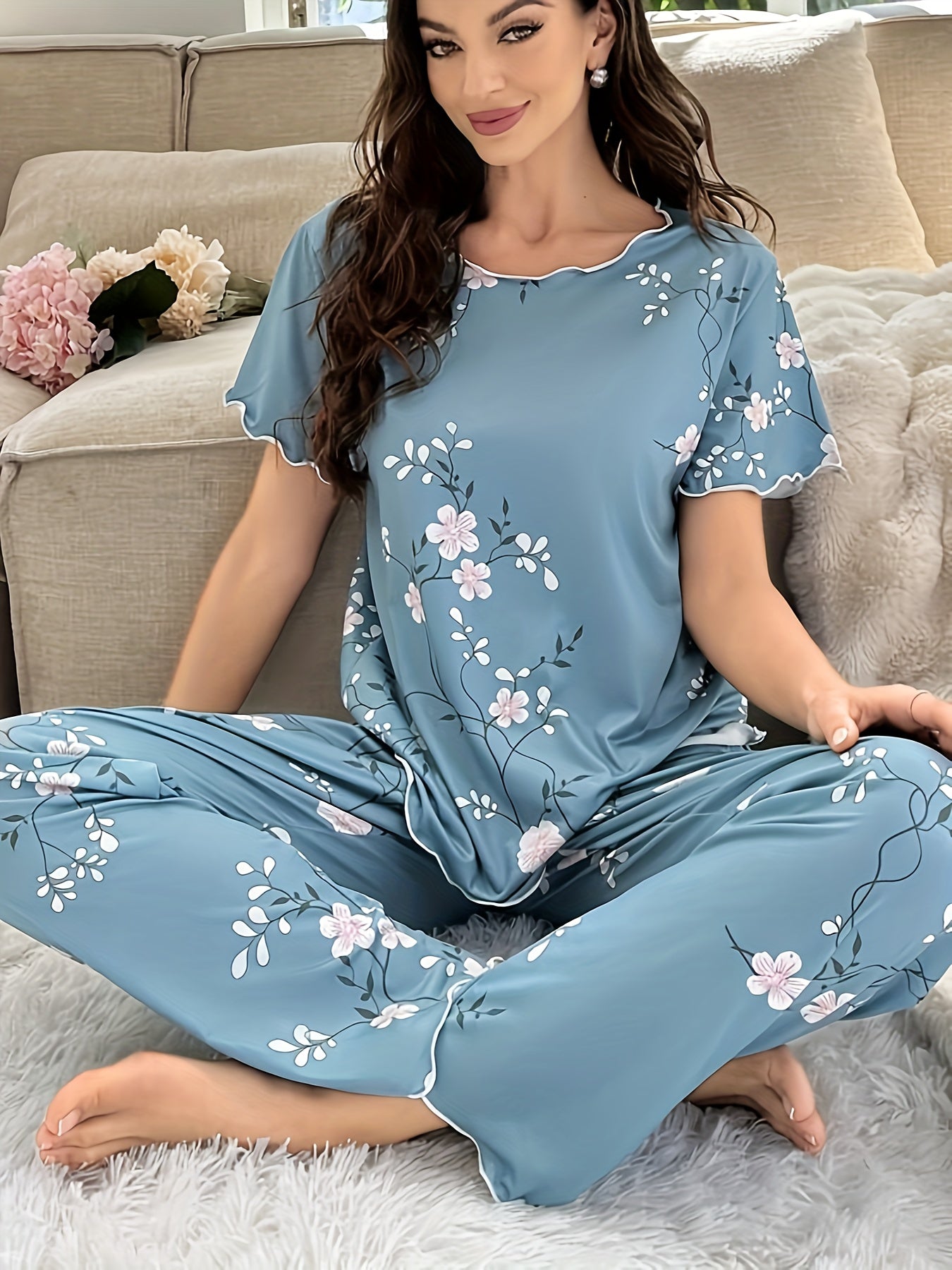 Women's sleepwear set with floral print, frill trim, short sleeve top, and elastic pants.