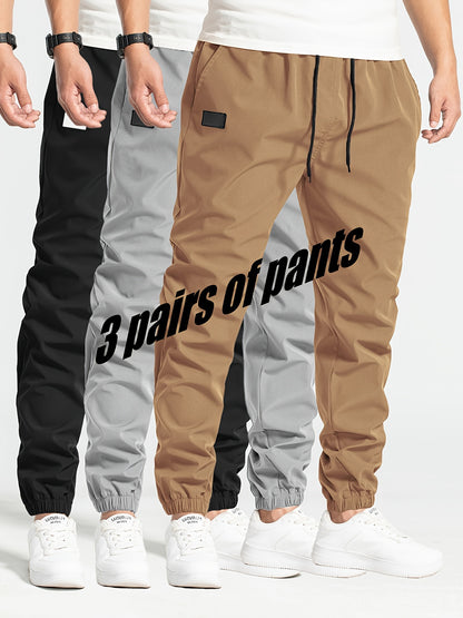 Three-pack of men's loose casual pants in 100% polyester solid color, featuring multi-pocket waist drawstring and non-stretch woven fabric, part of the Spring Collection, 180g/m².