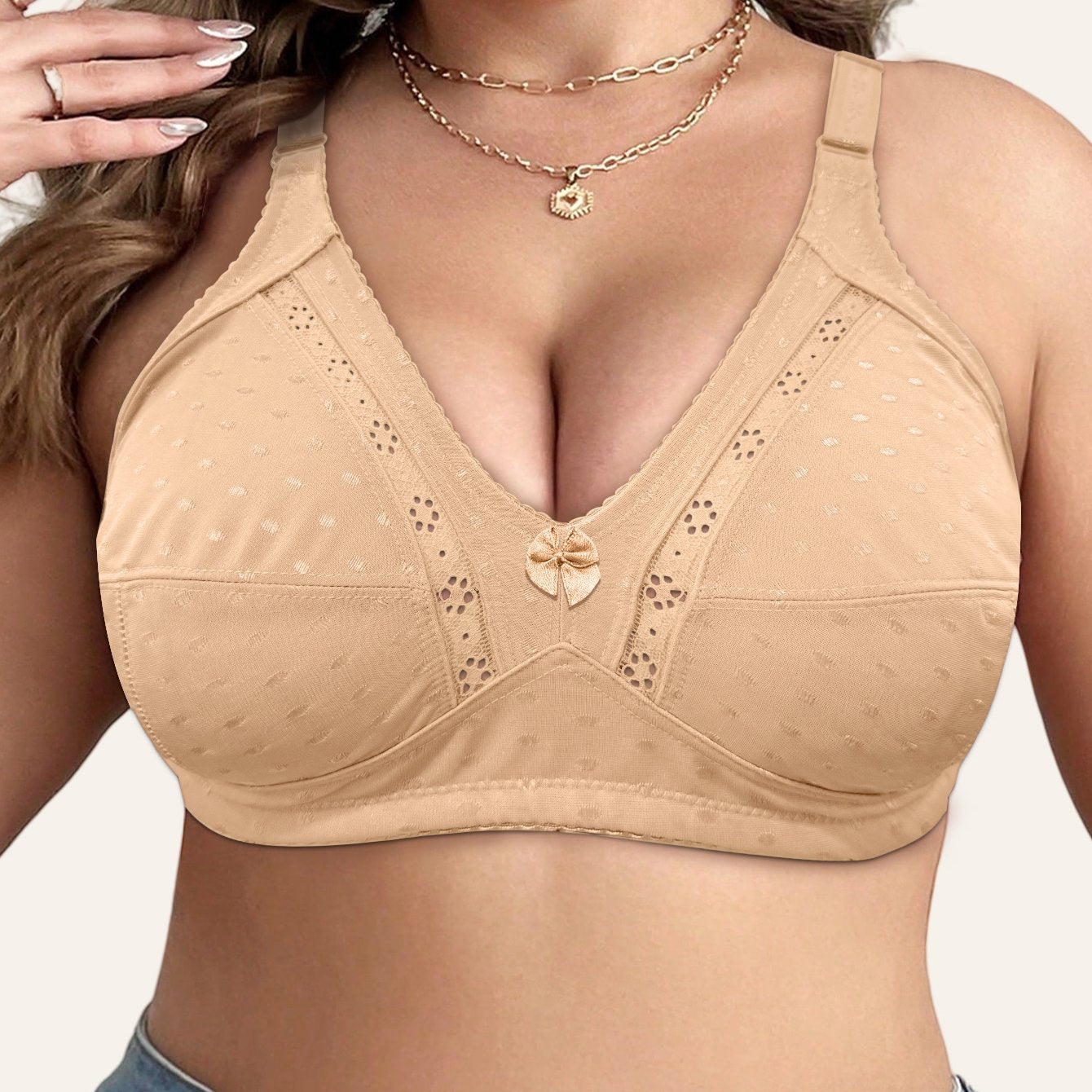 Elegant beige bra for plus size women with full coverage, wireless design, front bow detail, and floral cut-outs. Made with a soft nylon blend, wide straps, and no padding. Versatile for