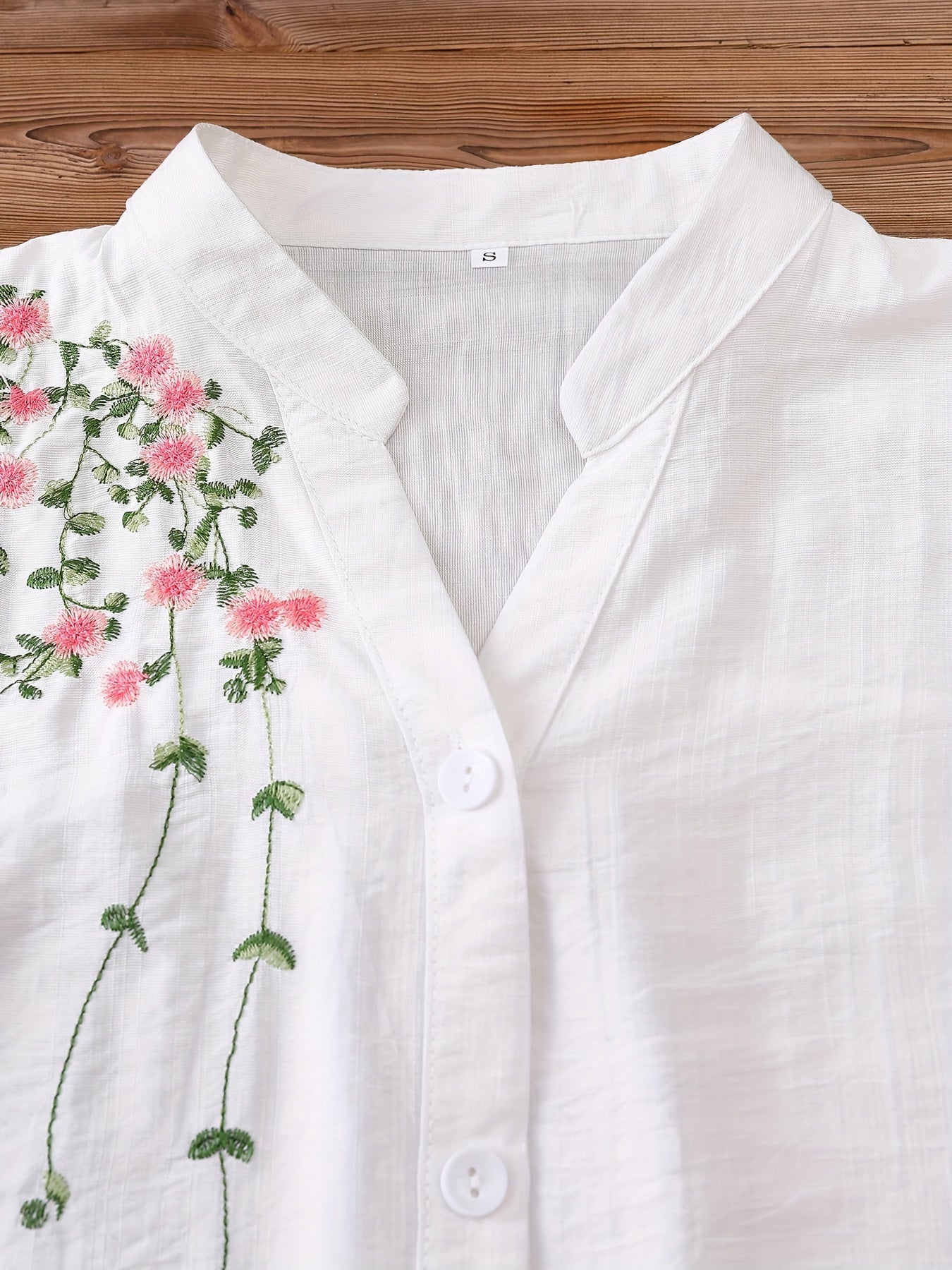 Floral embroidered women's blouse with v-neck and short sleeves, made of rayon and polyamide. Machine washable, ideal for spring and summer.