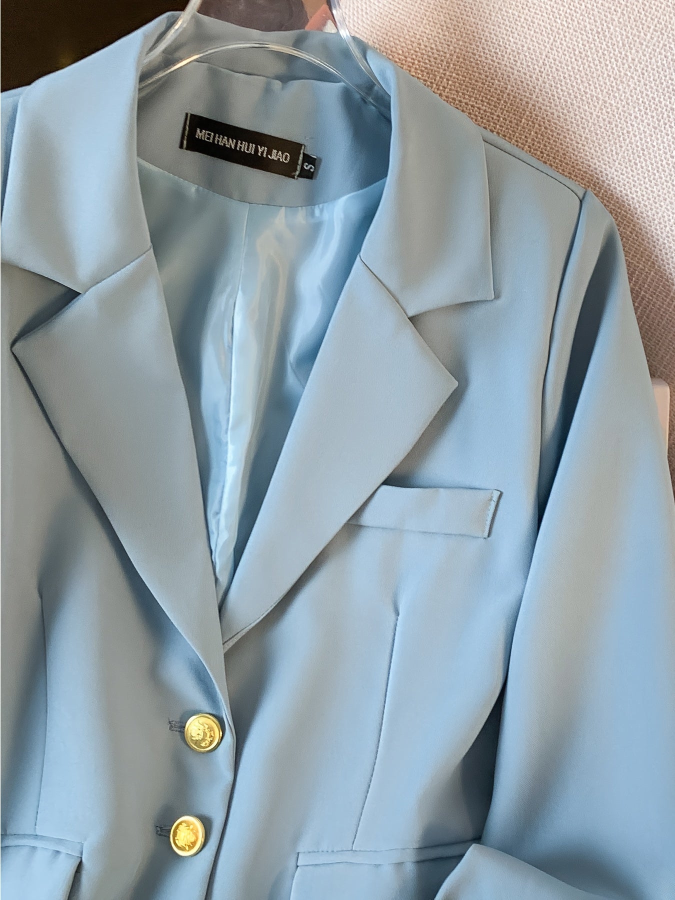 Stylish light blue blazer with golden button details for women, ideal for work in spring and fall.