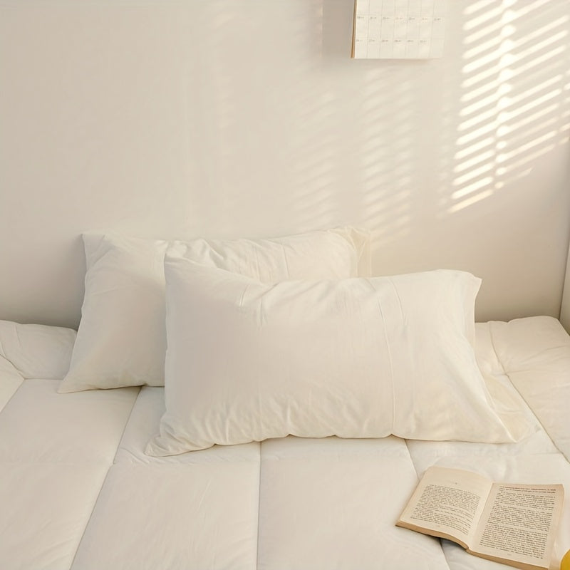 Two polyester pillowcases for bedroom use, featuring a multi-colored solid design.