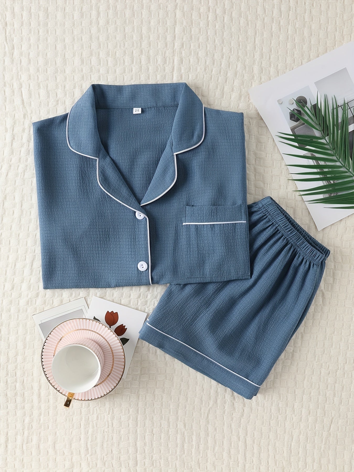 Basic pajama set for women, featuring a short-sleeve button-up top with lapel collar and elastic shorts.