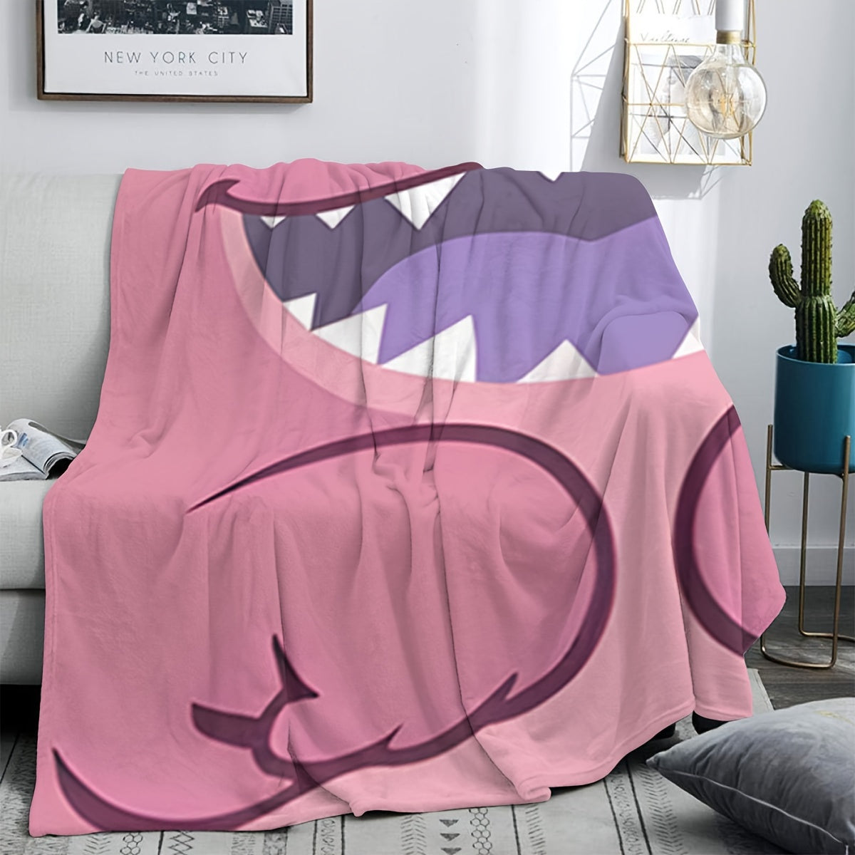 Pink plush throw blanket featuring a contemporary cartoon design. Made from soft polyester knit fabric, this multipurpose bedding is suitable for all seasons. Perfect for adding comfort to your bed, sofa, office nap, or as a travel blanket. Makes an