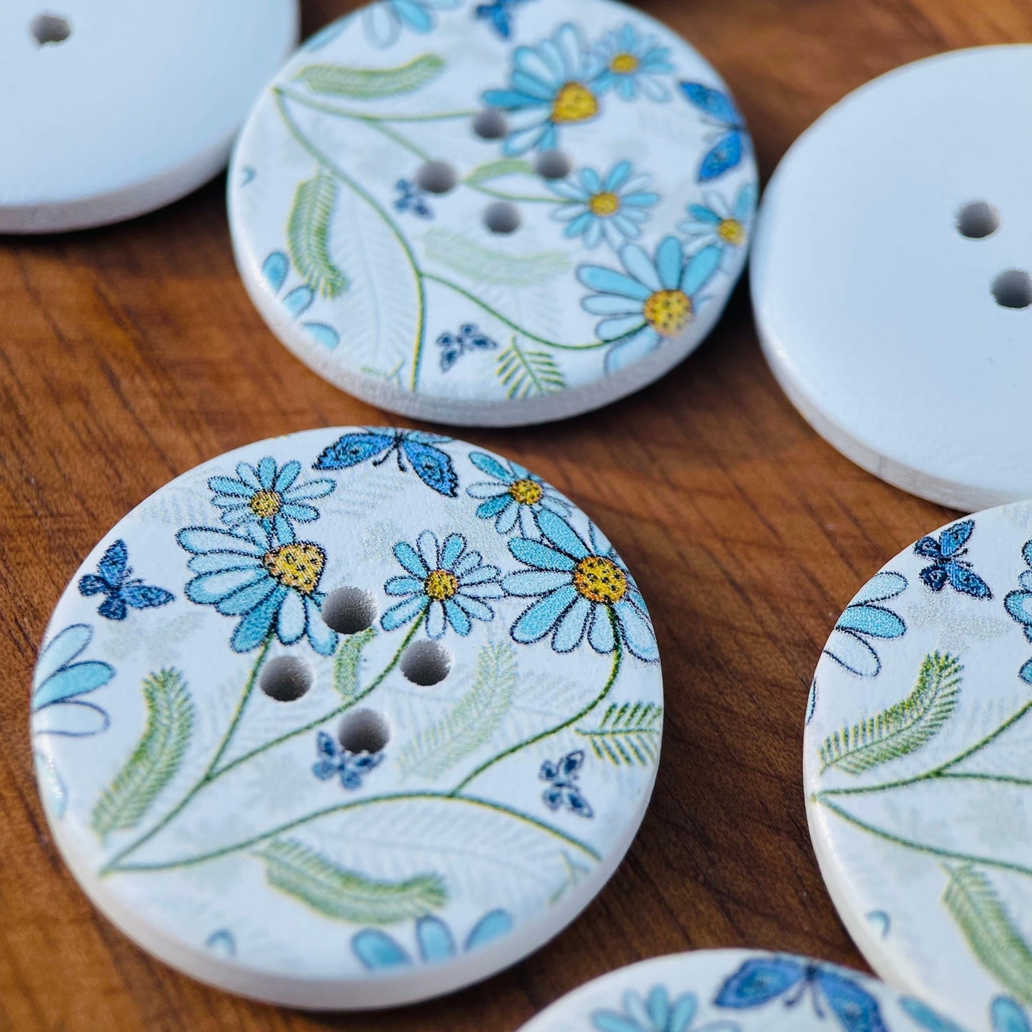 A set of 10 large decorative flower and butterfly buttons made of natural wood, each measuring 30mm in size and featuring 4 holes for sewing.