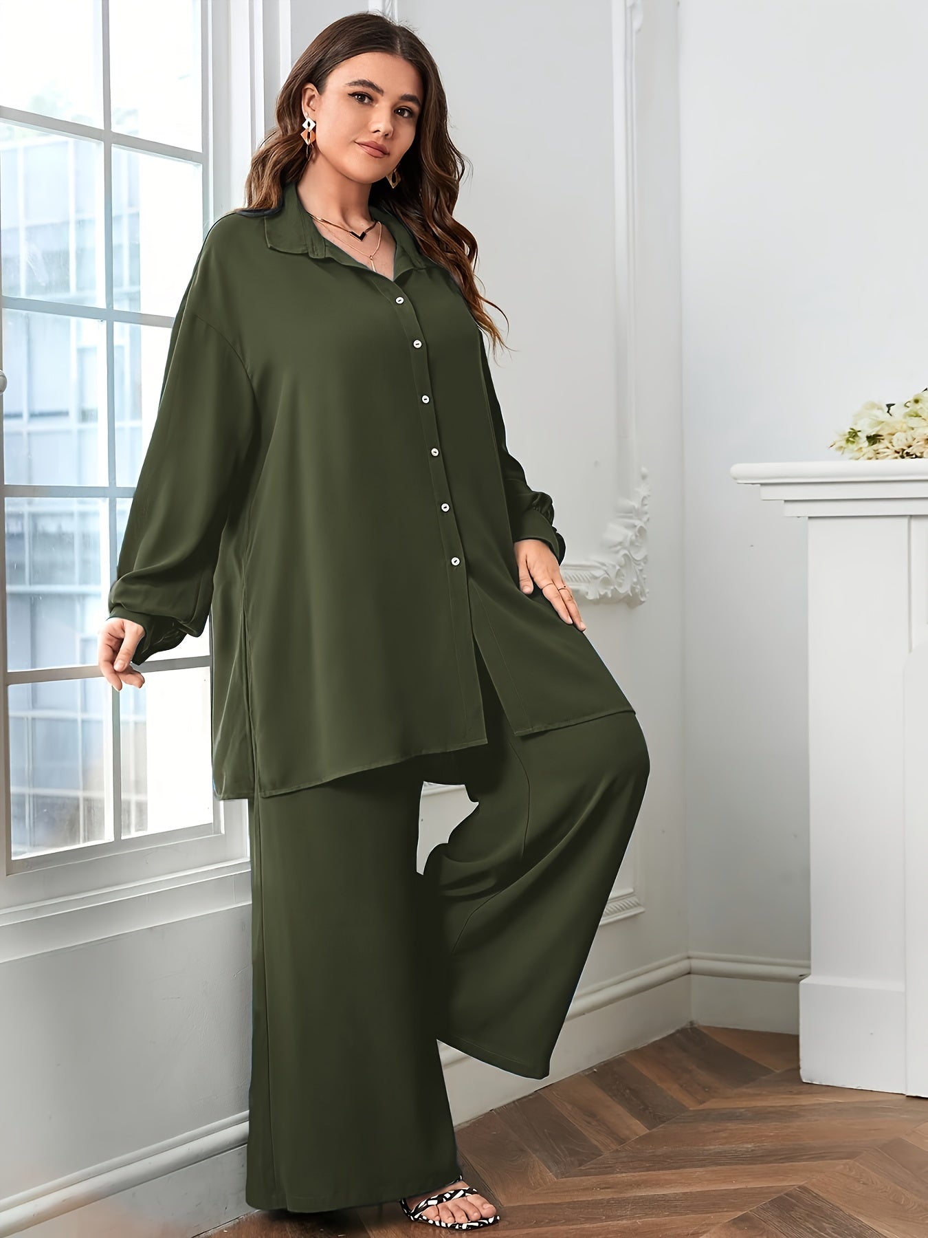 Black polyester blend pants with split details and a relaxed blouse comprise an elegant oversized V-neck two-piece set.