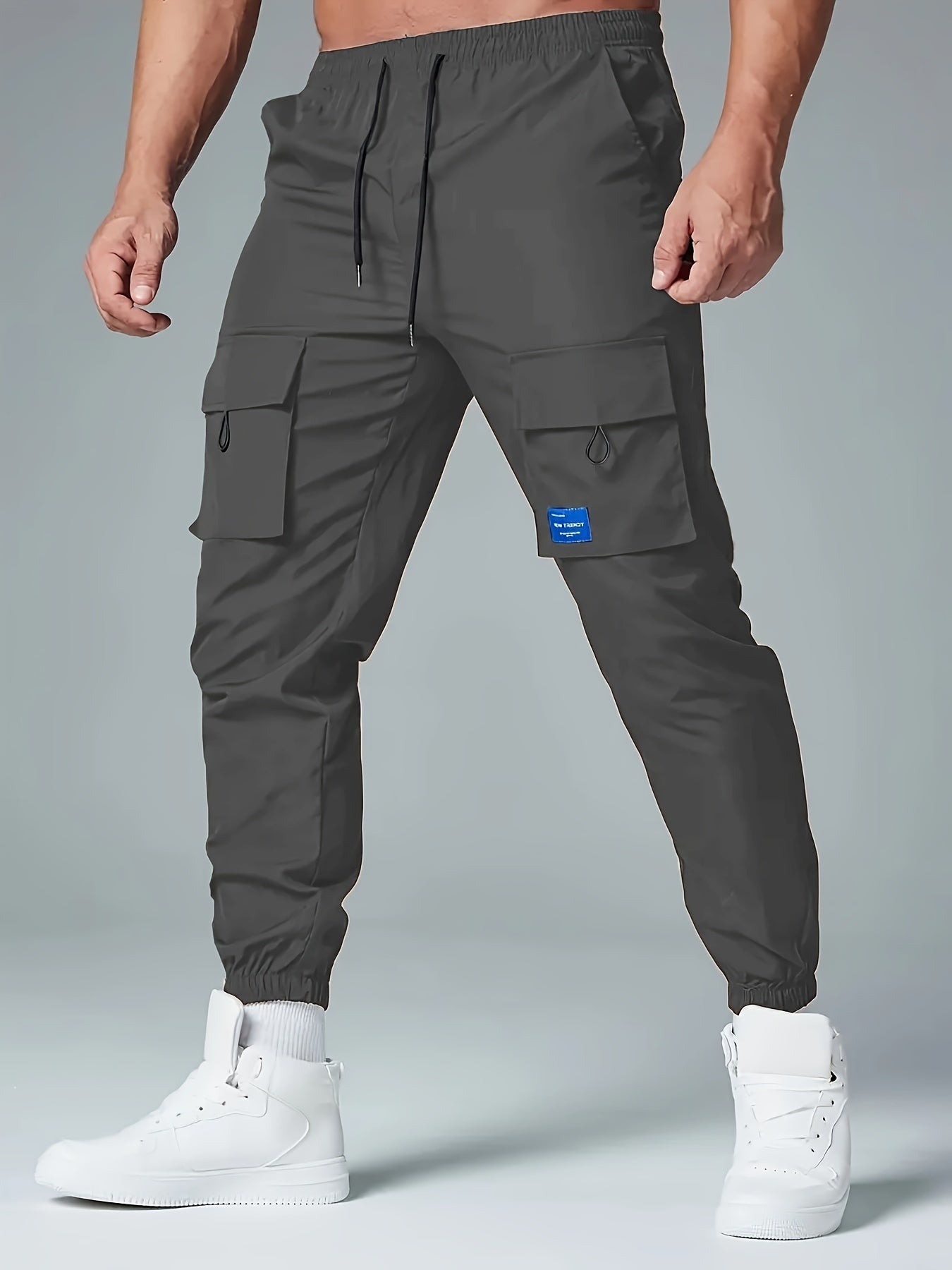 Men's casual drawstring cargo pants with multiple pockets made of polyester, mid-waist, ideal for spring and fall seasons.