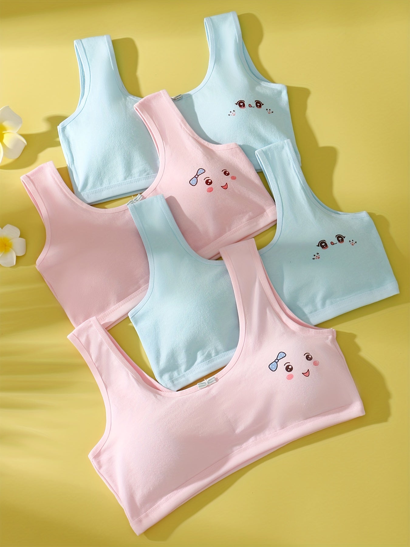 4 comfy cotton bras for girls aged 7-13 with cute animal illustrations in solid colors. Stretchy and machine washable. Includes white, yellow, blue, pink. Ideal for elementary to high