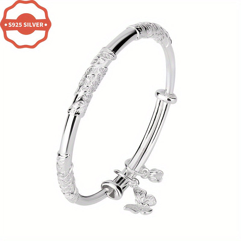 Add a touch of boho luxury to your wardrobe with this stunning 925 silver bangle bracelet featuring 18K golden plated charms. Handcrafted with floral designs, butterfly, and bell pendants, this hypoallergenic cuff is perfect for women who love unique