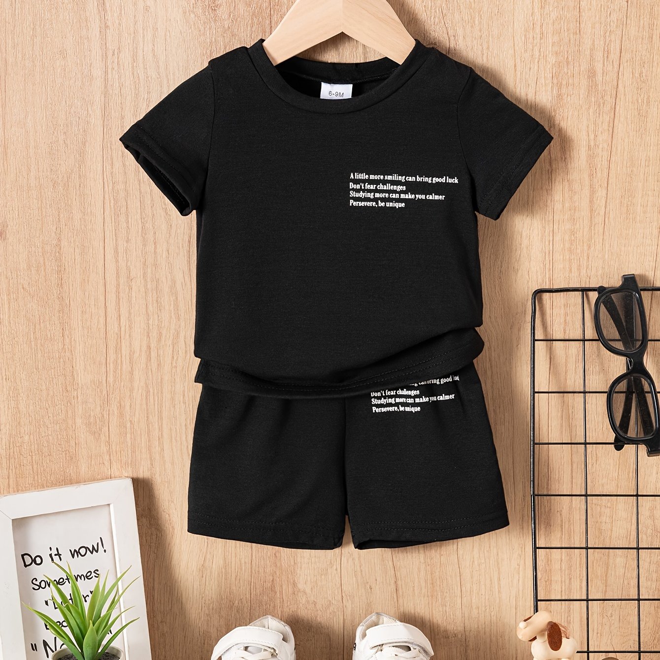 Two baby boy casual "slogan" t-shirt and shorts set made of polyester knit fabric, featuring a cute regular fit. The set includes a short sleeve crew neck tee with solid color shorts