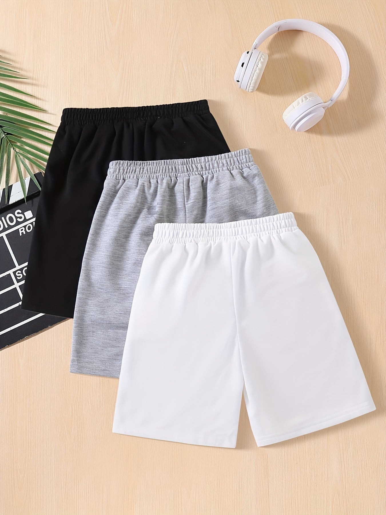 Three-pack of boys' summer shorts in solid colors, made from polyester knit with slight stretch, featuring elastic drawstring waist and regular fit. Ideal for sports and leisure activities