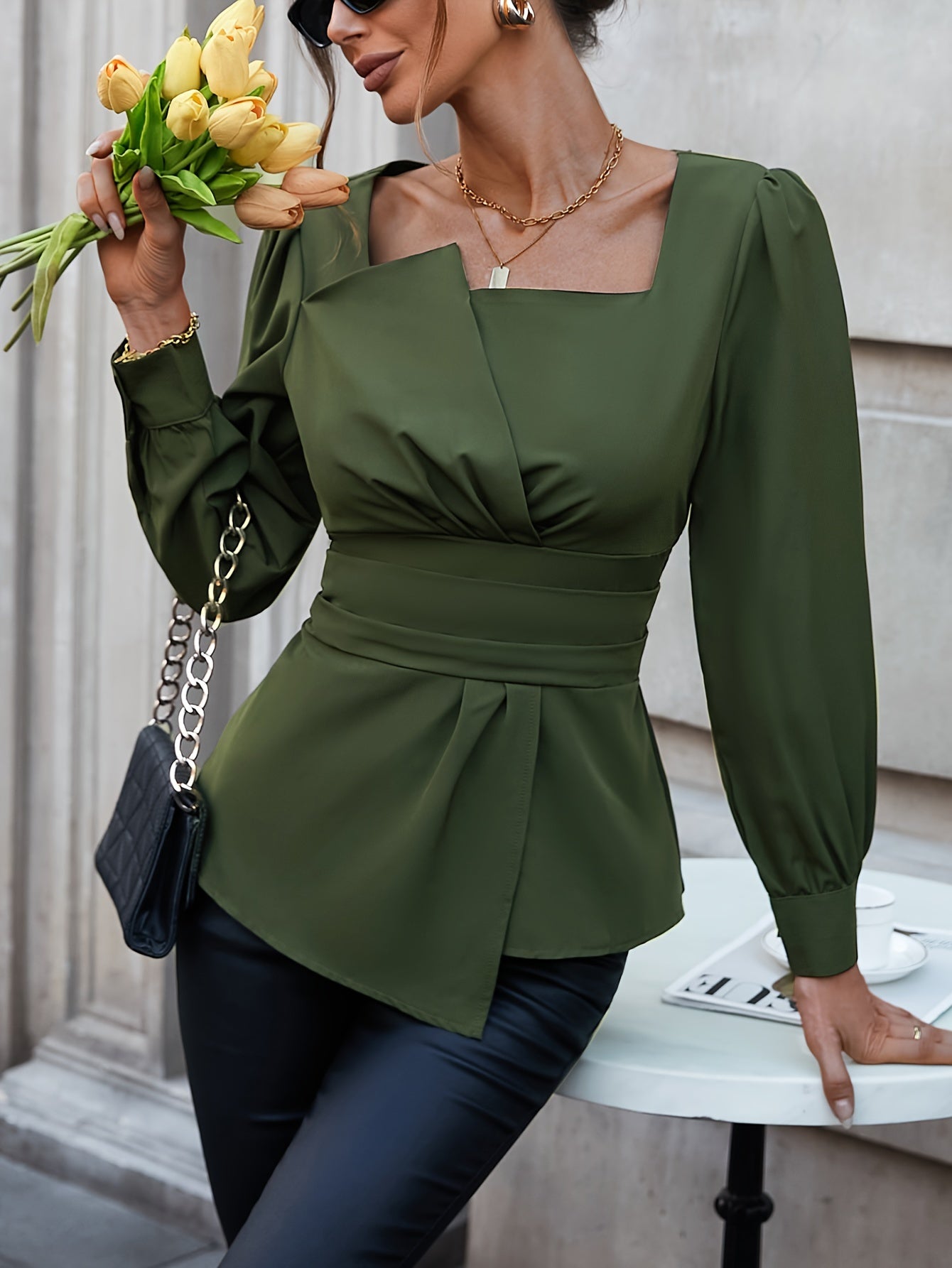 Sophisticated olive green blouse with square neckline, puffed sleeves, and asymmetric hem. Ideal for spring and summer, machine washable and dry cleanable.