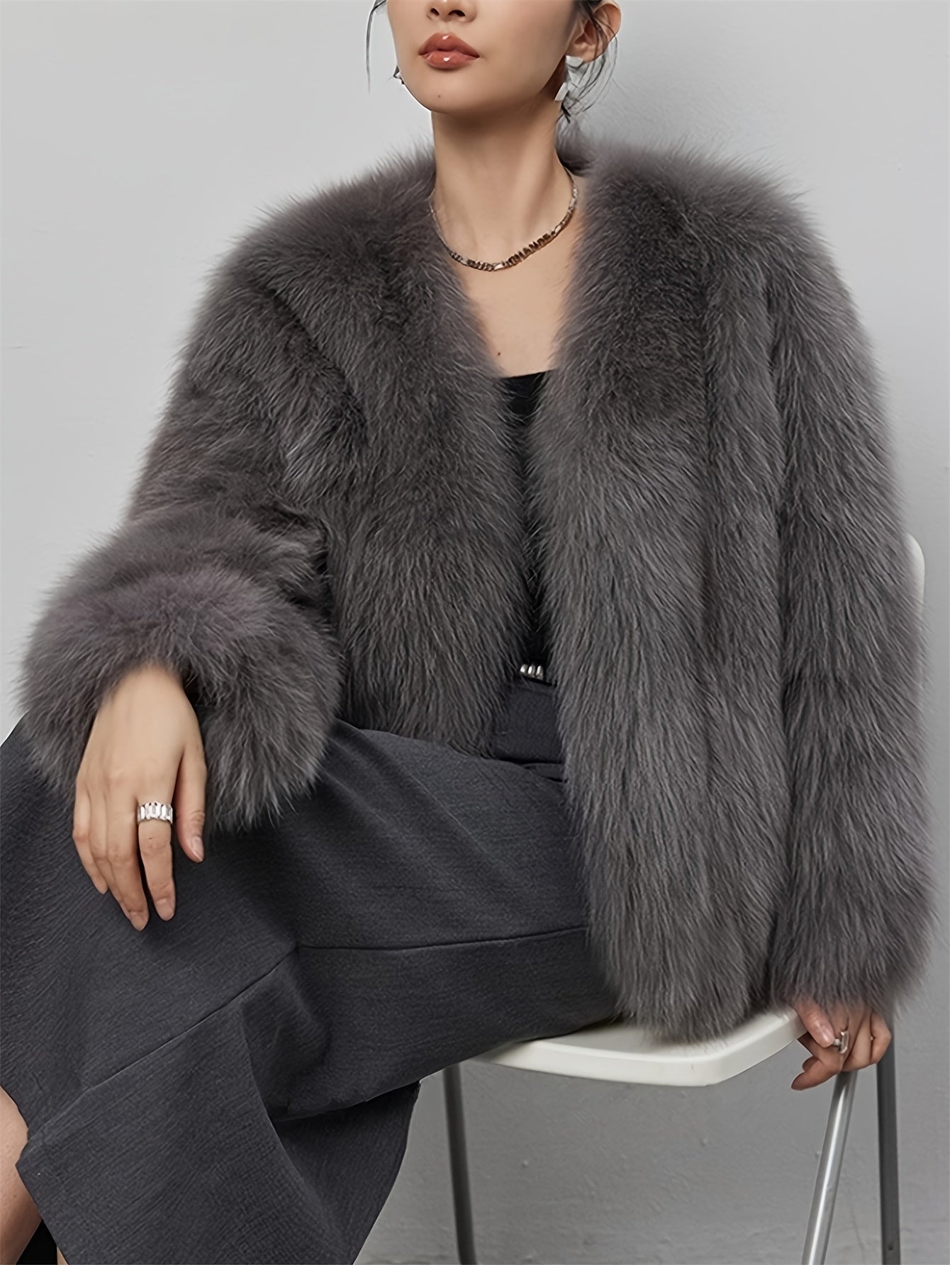 Stylish women's coat in light gray faux fur with fluffy collar, perfect for cold weather