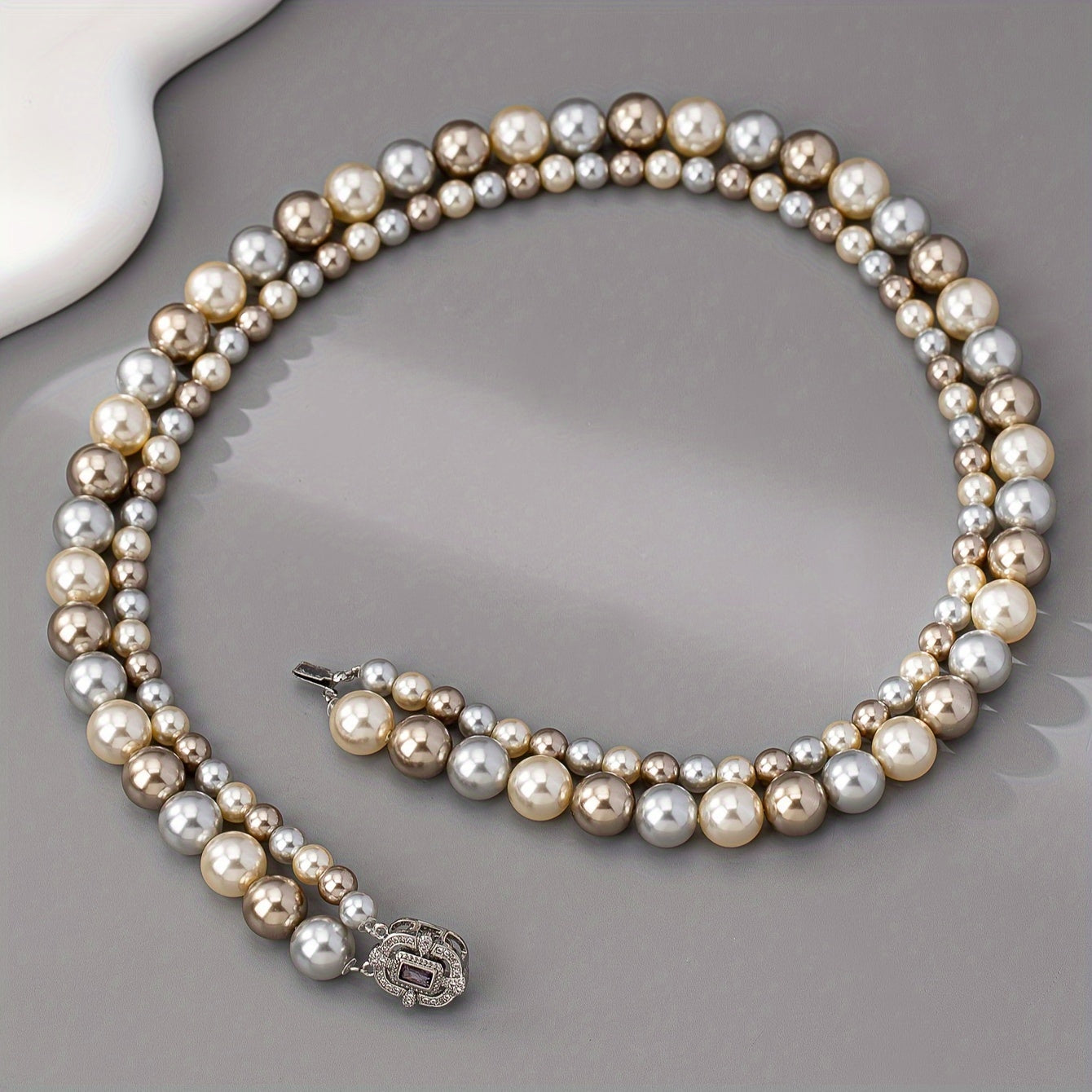 For special occasions and weddings, adorn yourself with our exquisite double-strand pearl necklace featuring 22K golden plating and a zirconia clasp. This elegant piece comes with detachable layered imitation pearls for a timeless and luxurious look.