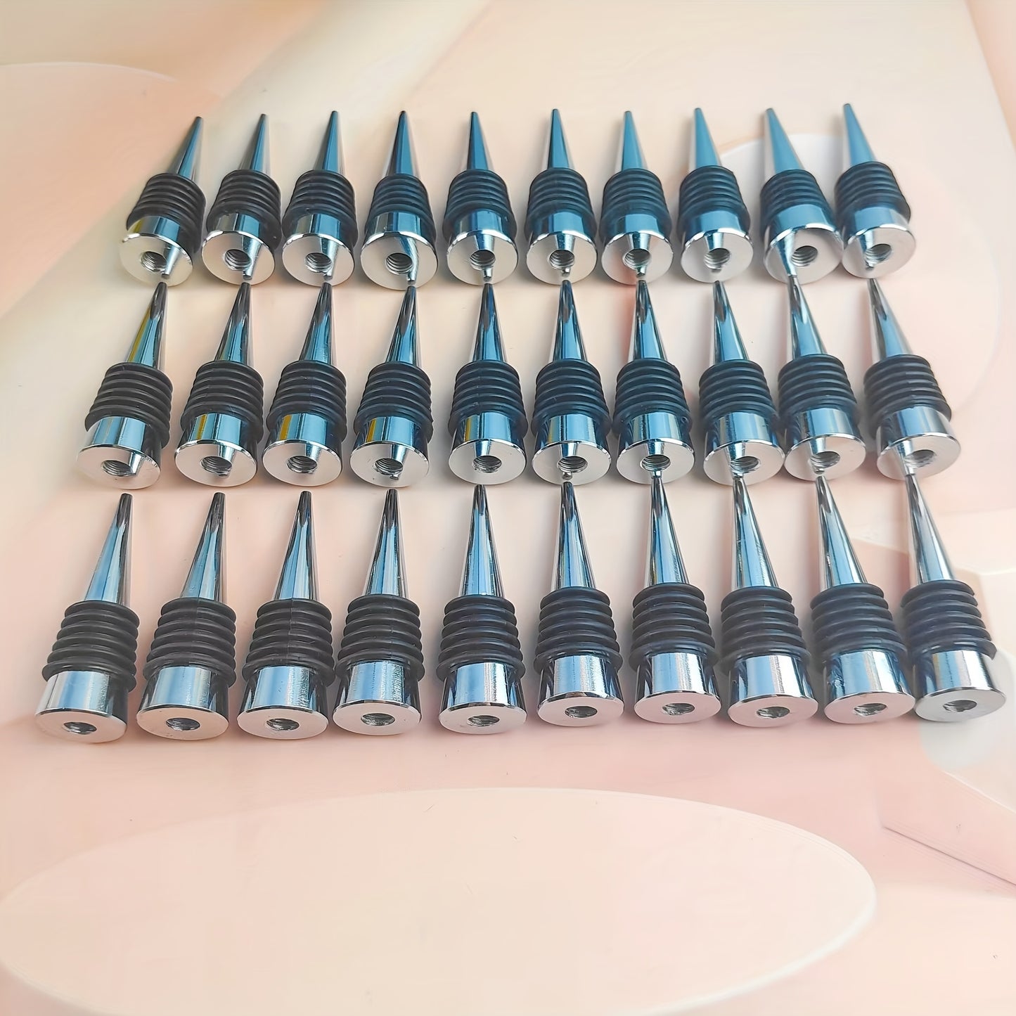 Wine stoppers in sets of 12, 22, or 30 made of stainless steel for red wine and champagne bottle preservation. Great for bar accessories.