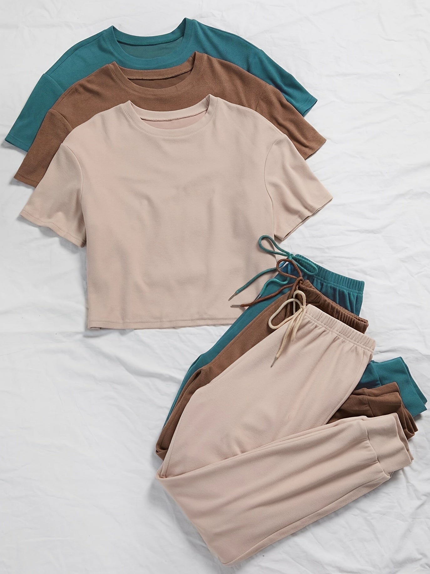 3 sets of women's solid color lounge sets with comfortable tee and tie front pants. Available in multiple colors for relaxed casual wear.