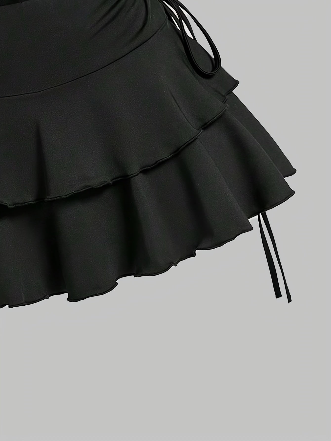 Black polyester knit outfit for spring/summer with off-shoulder top and ruffle skirt.