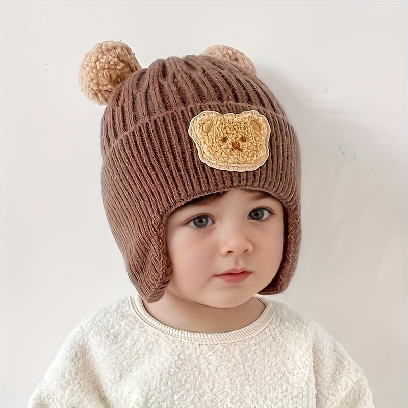 Soft polyester knit hat with cozy bear theme and ear warmers for young children, perfect winter gift for boys and girls aged 0-3 years. Comes in khaki, coffee, and ivory colors.