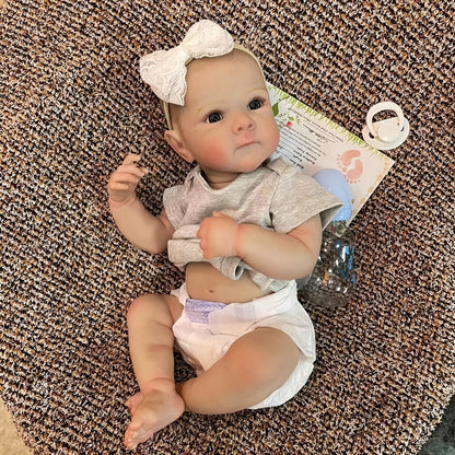 20" lifelike waterproof vinyl reborn girl doll with realistic 3D painted skin and hand-painted hair. Bathable and comes in a comfy gray outfit with headband. Perfect for girls.