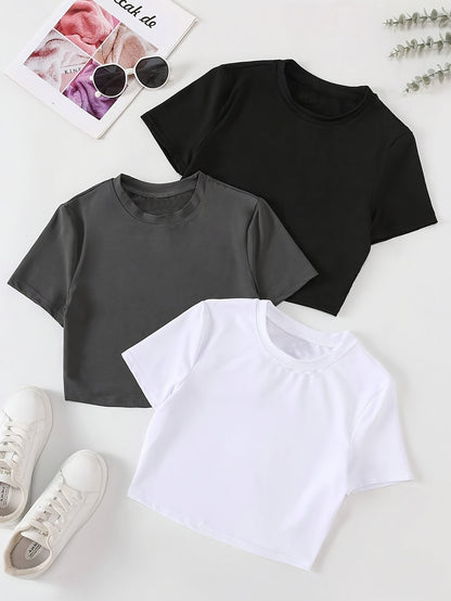 Three women's slim fit crop tops in black, white, and dark gray. Made of polyester and machine washable. Great for layering.