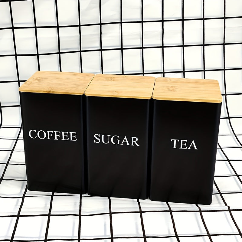 Three square metal canisters with wooden lids - one for tea, one for sugar, and one for coffee.