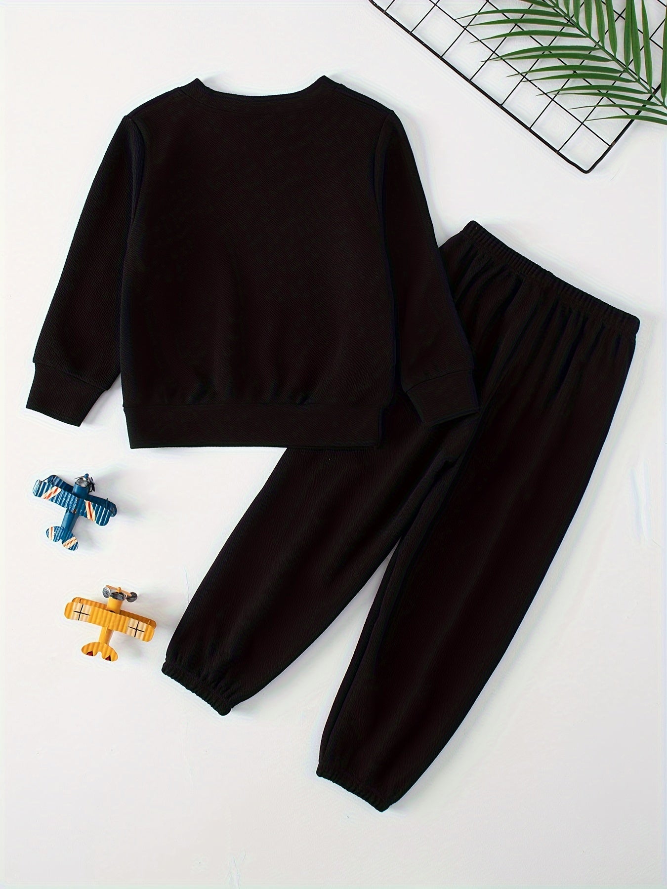 Children's casual sweatshirt and pants set made of polyester and spandex blend. Solid color with round neck, long sleeves, and knit fabric. Regular fit with pocket detail, suitable for