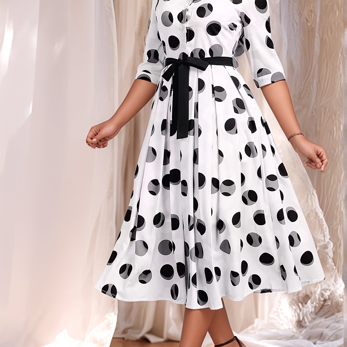 Vintage-inspired midi shirt dress with belt, polka dot print, collared design, and flared skirt in machine washable polyester.