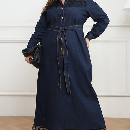 Women's plus size navy blue denim dress with long sleeves, button-up shirt collar, fringe hem, belt detail, and cotton/polyester blend. Machine washable.