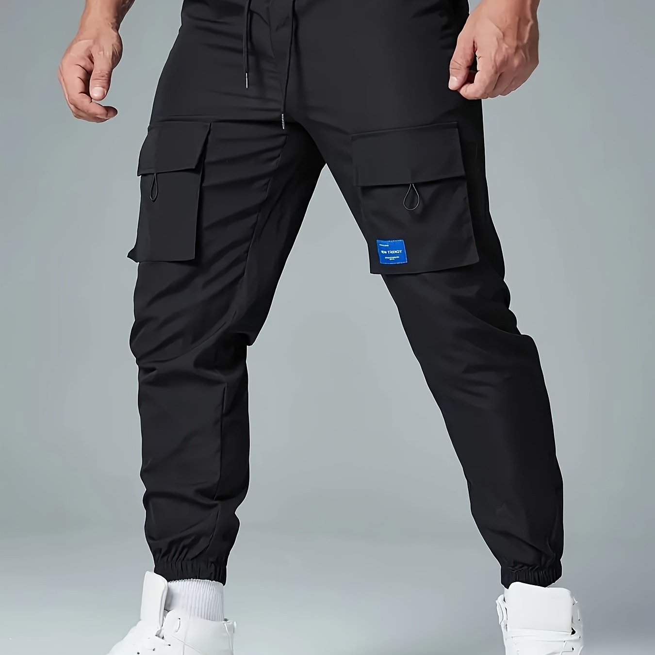 Men's casual drawstring cargo pants with multiple pockets made of polyester, mid-waist, ideal for spring and fall seasons.