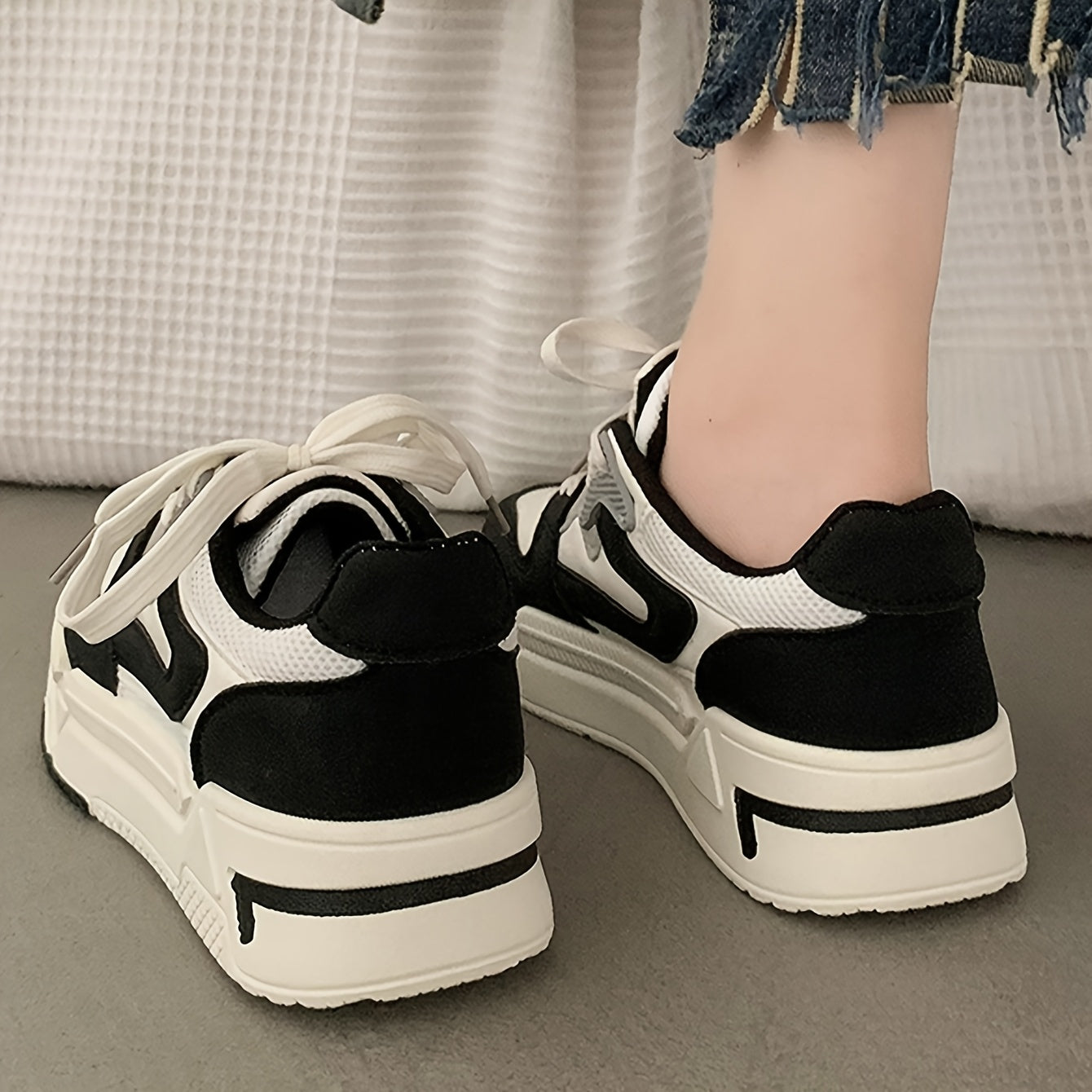 Black and white slip-on casual sports shoes for women with non-slip rubber sole, lightweight and dirt-resistant for skateboarding.