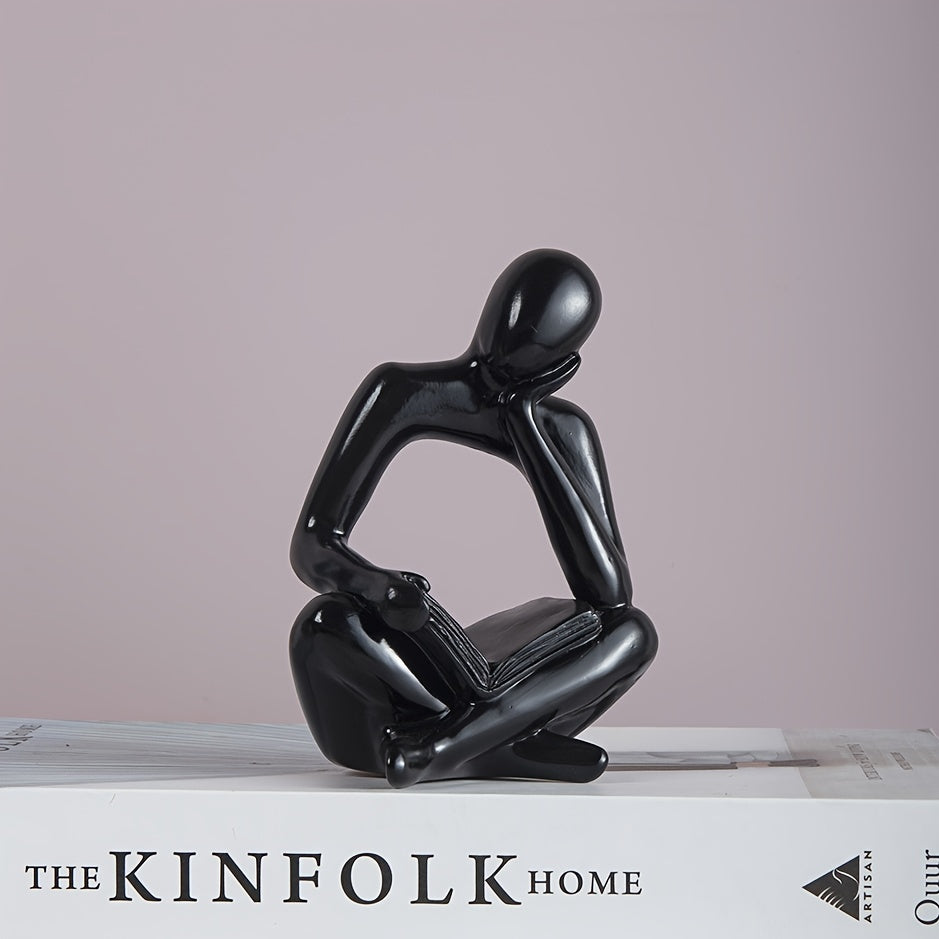 Abstract figure reading book with one hand ornament.